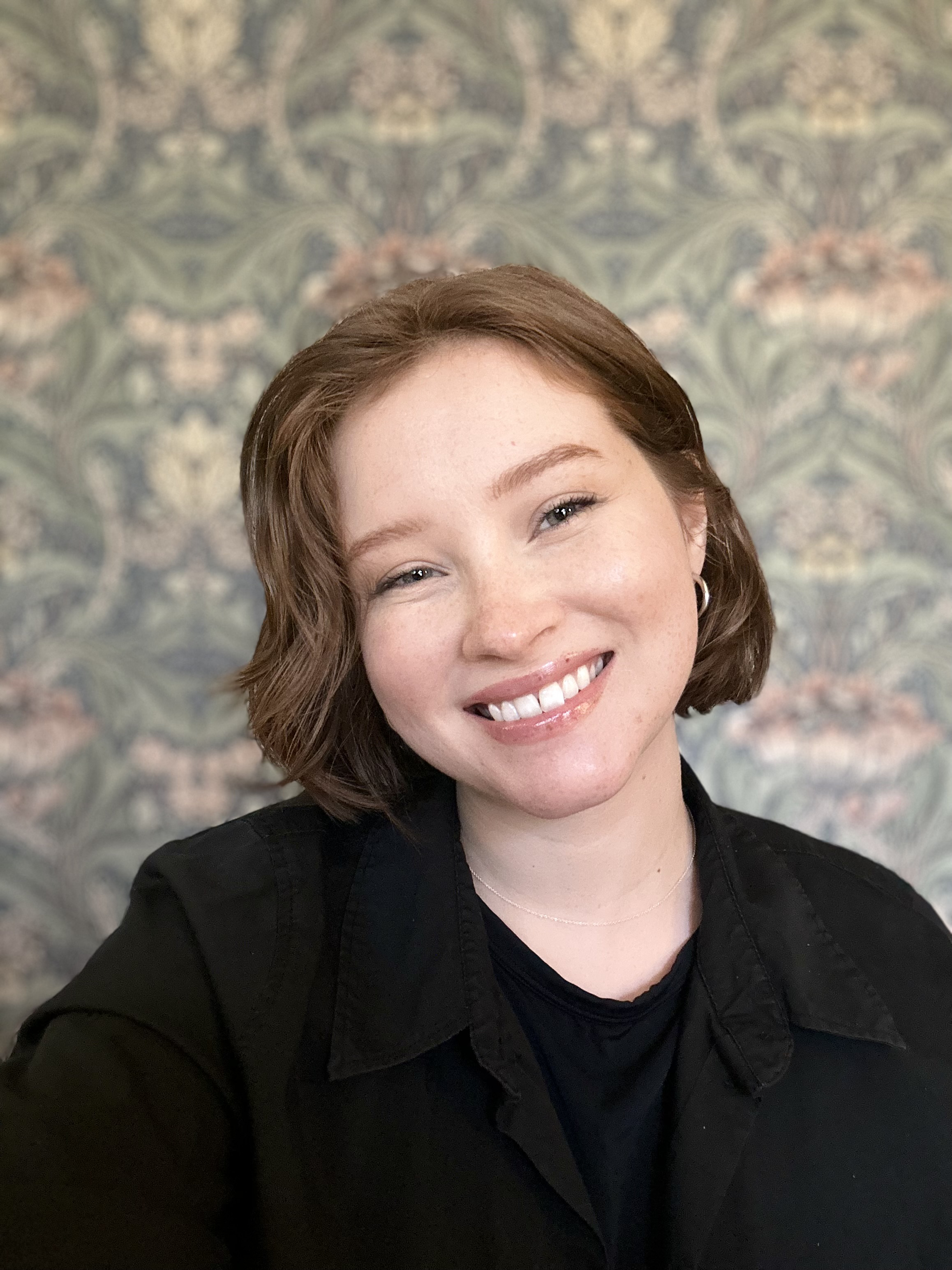 Headshot of Kira wearing a black jacket.