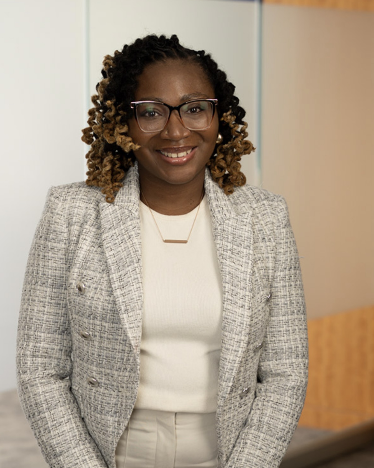 Alexus wearing a white shirt and gray blazer.